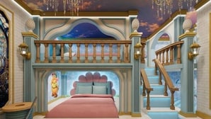 Una camera da letto con un letto, una scala e un soffitto decorato.