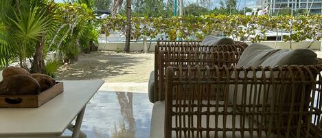 A wicker outdoor seating area with a table and a small fruit basket.