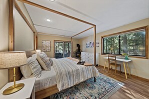Ein Schlafzimmer mit einem Himmelbett, einem Schreibtisch und einem großen Fenster.
