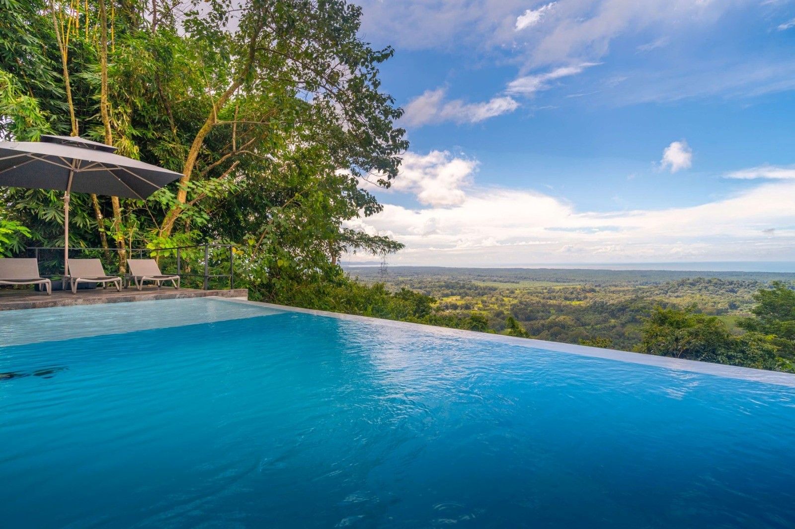 A swimming pool with a view of a forested landscape.