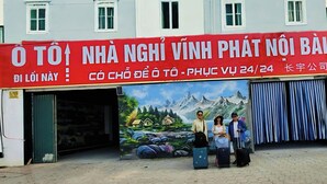 A building with a large sign indicating a 24-hour service. - Vĩnh Phát Hotel (Soc Son)