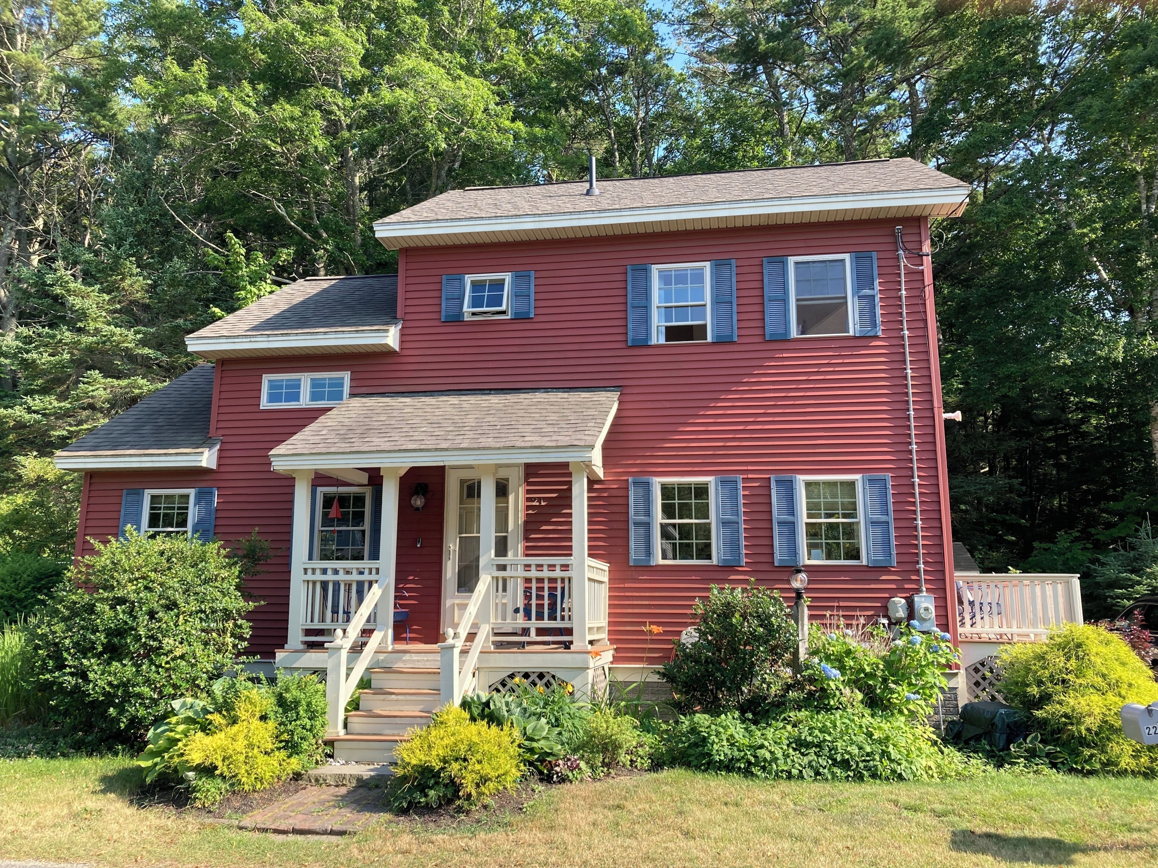 A two-story house with a porch, a front door, and a mailbox.