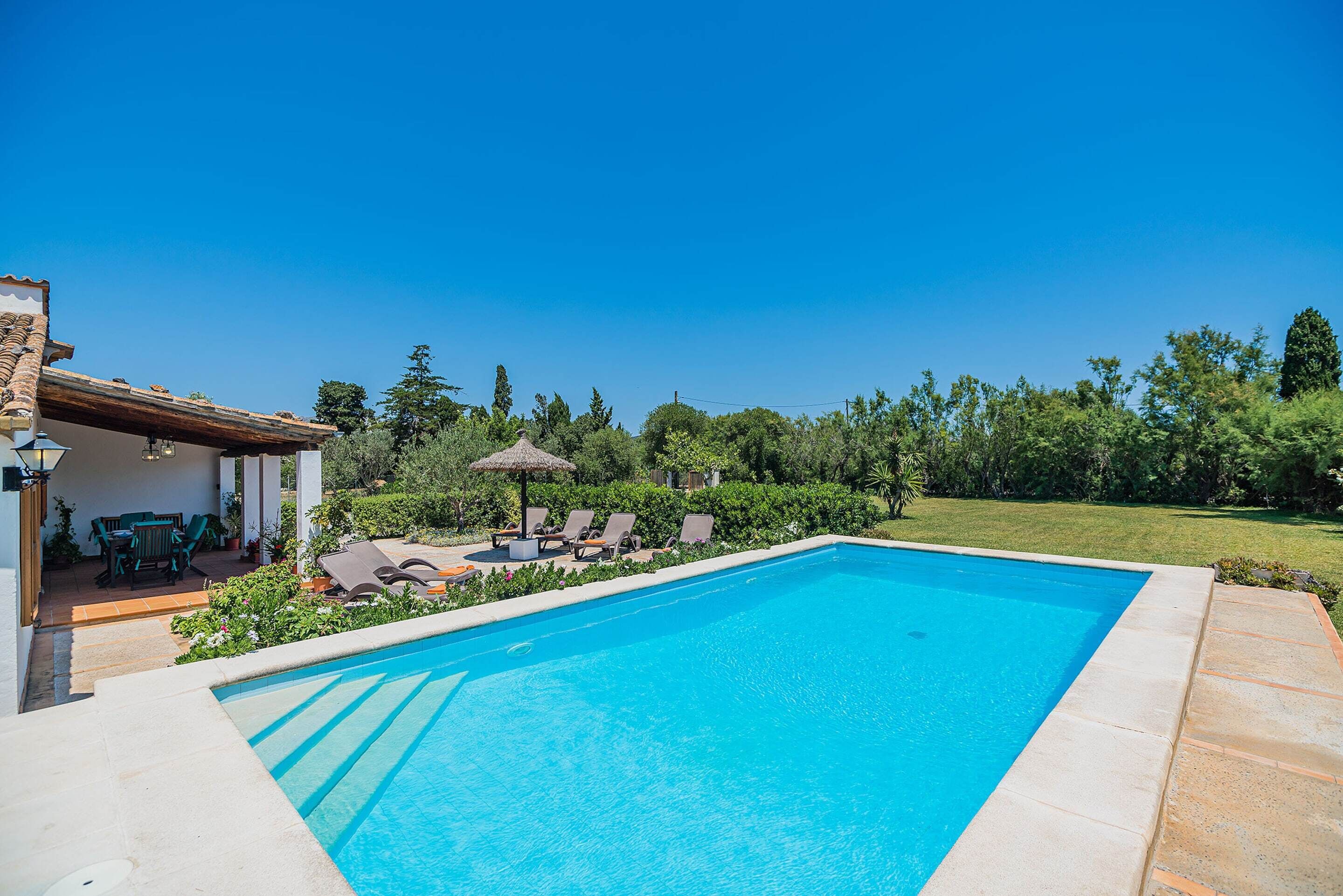 A swimming pool with lounge chairs and a patio area.