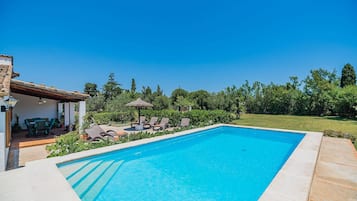 A swimming pool with lounge chairs and a patio area.