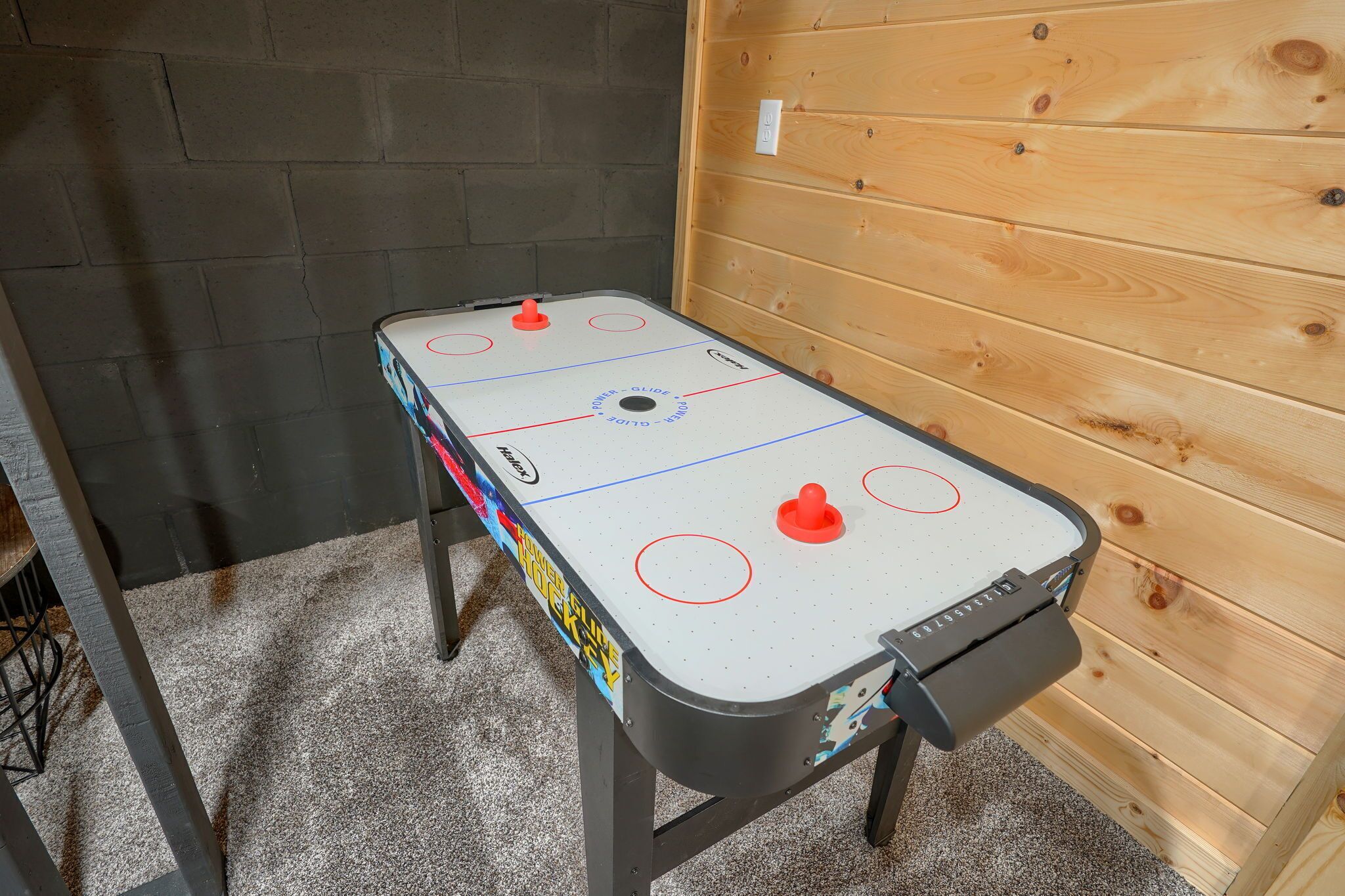 Un juego de hockey de mesa con un soporte para el disco, una portería y una mesa con líneas.