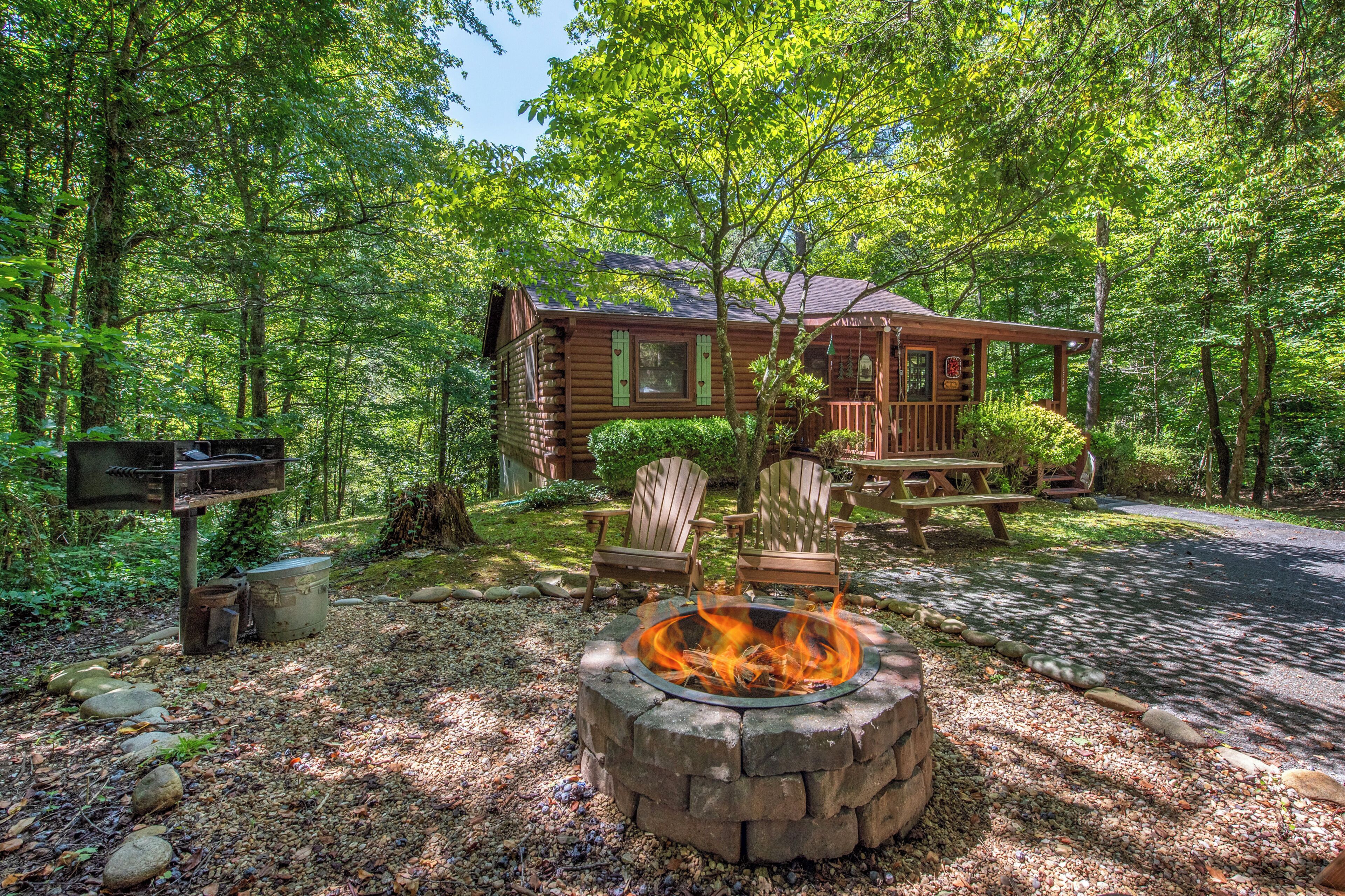 A cabin with a fire pit, outdoor seating, and a mailbox.