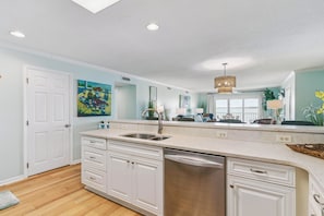 A modern kitchen with white cabinetry, a stainless steel sink, and a dishwasher. - Isle Be Back, Oceanfront Escape sleeps 4 (St Simons Island)