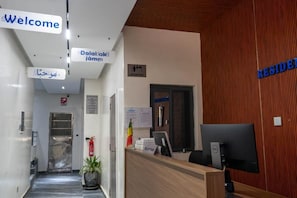 A reception area with a reception desk, a 'Welcome' sign, a 'Reception' sign, and a 'Residence' sign. - chambre c1 (Dakar)