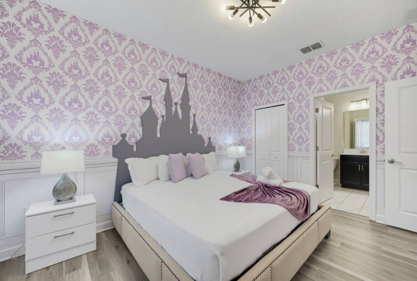 Quarto com cama, mesas de cabeceira, cômoda e porta para outro aposento.