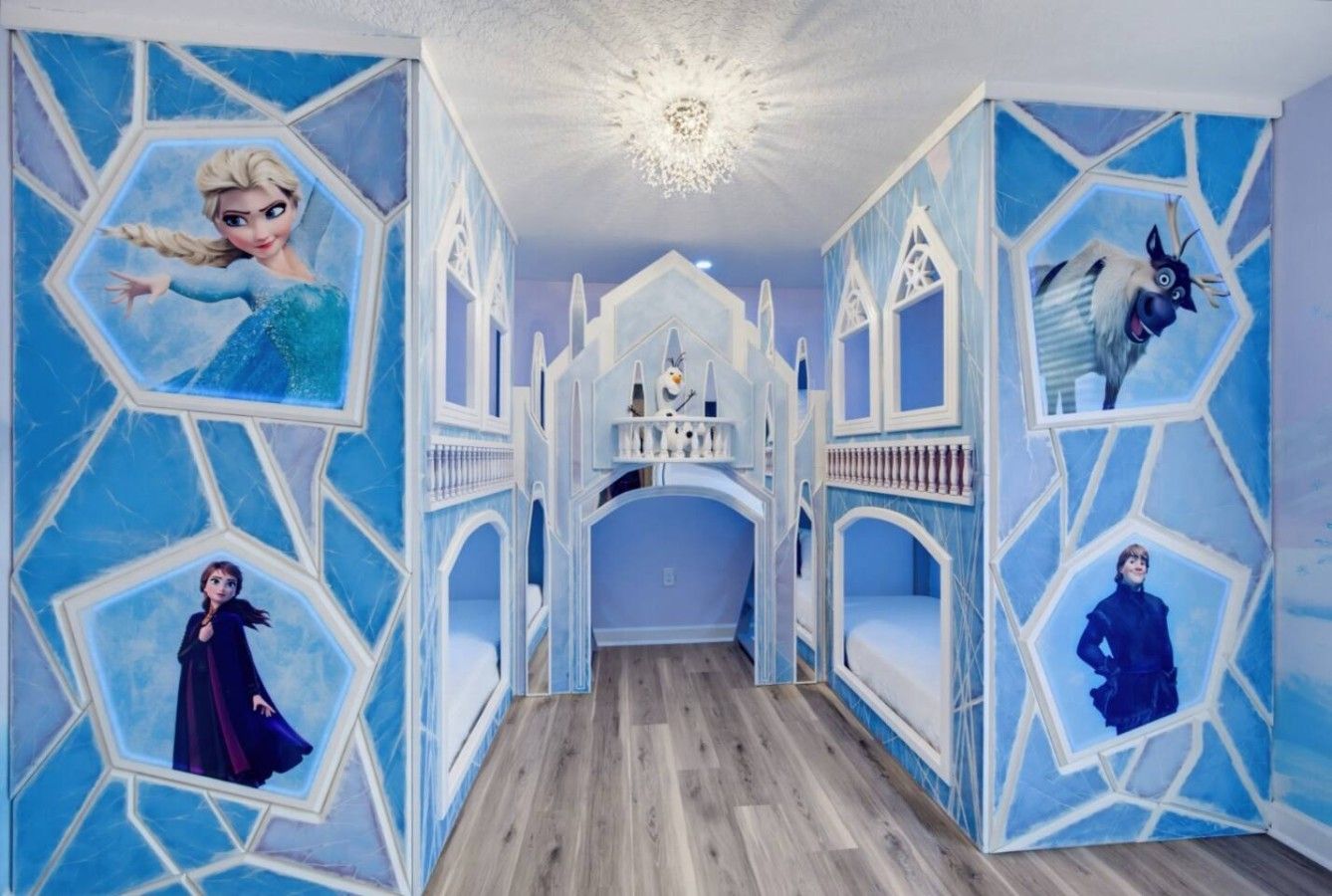 Une pièce avec un mur orné d’un motif géométrique, un plancher en bois et une porte d’entrée centrale en forme d’arc.