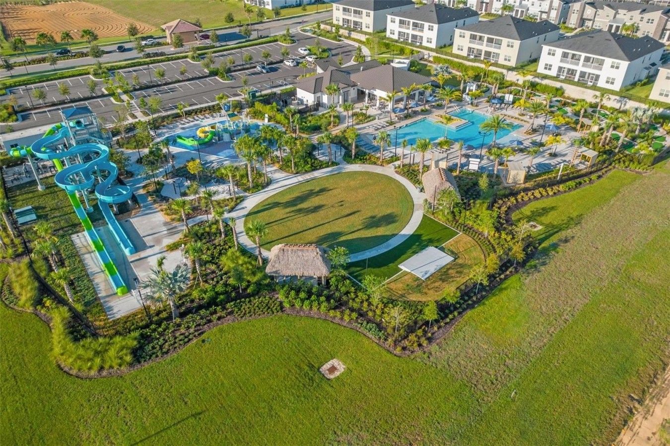 Ein Luftbild eines Resorts mit Schwimmbad, Wasserrutschen und Tennisplatz.