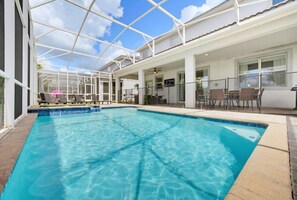 An indoor swimming pool with clear blue water, surrounded by a covered area with seating and a glass enclosure. - Private Pool, Theater & Themed Rooms (Four Corners)