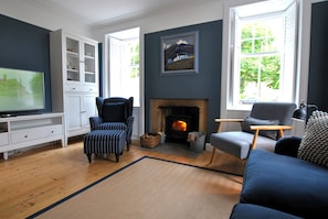 A living room with a fireplace, a television, and a large window. - Crowstep Cottage- Character Crail apartment (Crail)