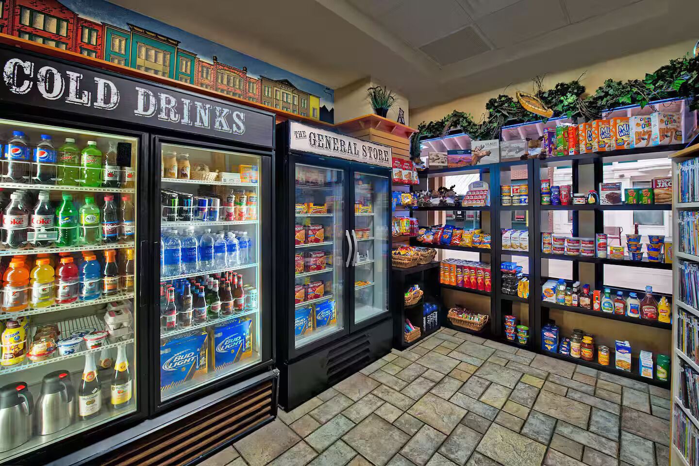 A convenience store with refrigerated sections for cold drinks and a general store area with snacks and beverages.