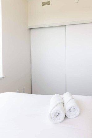 Ein Hotelzimmer mit einem Bett, einem Fenster und einer weißen Wand.