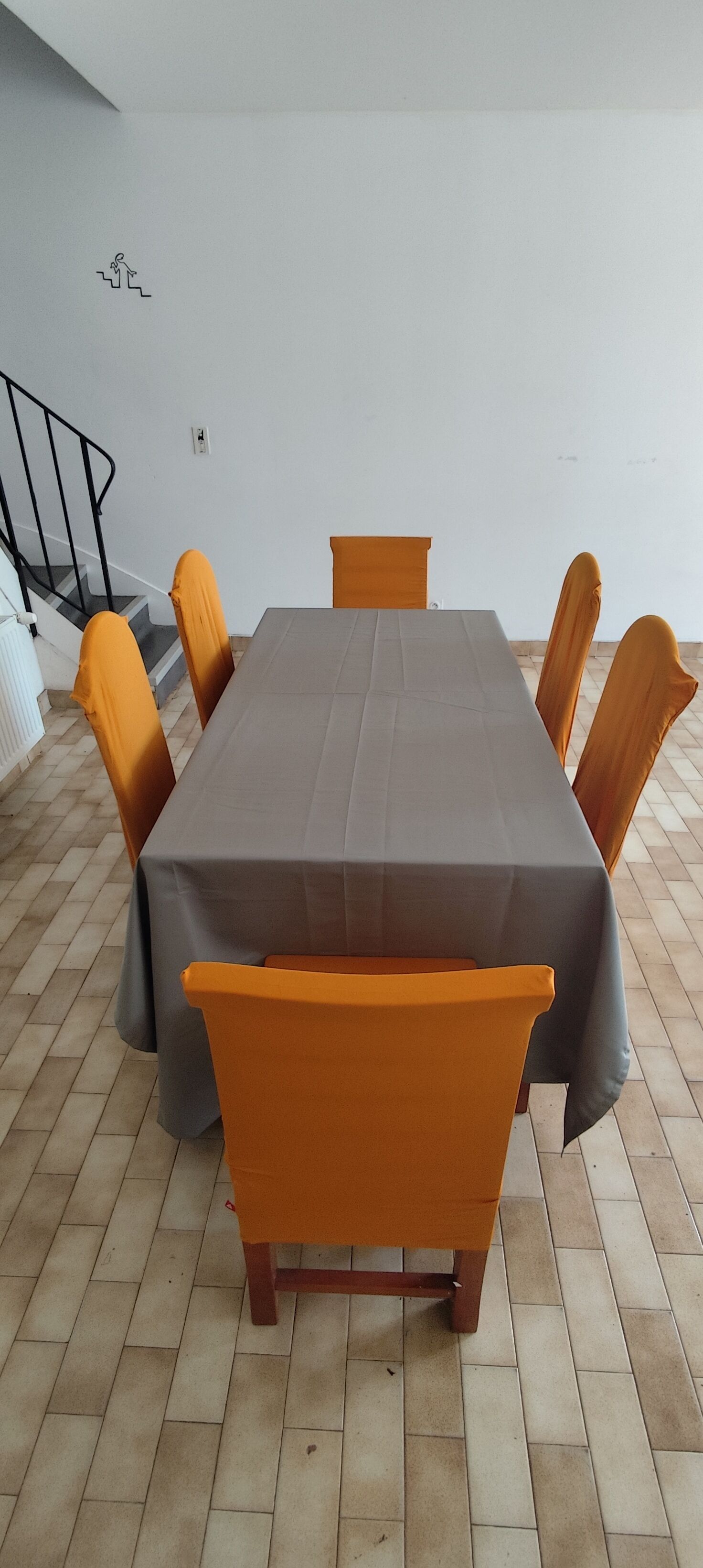 A conference table with chairs, a staircase, and a wall-mounted emergency exit sign.