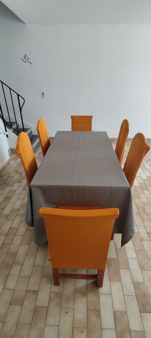 A conference table with chairs, a staircase, and a wall-mounted emergency exit sign. - Spacious House in the Peaceful Countryside (Val-Sonnette)