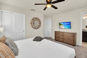 A bedroom with a bed, dresser, ceiling fan, and a wall-mounted TV. - Mickey | Minions | Frozen | Pool | Near Disney 4265 (Davenport)