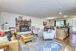 A spacious living room with a fireplace, a dining area, and a kitchen. - Gardner Mountain Hideaway (South Lake Tahoe)