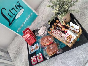 A tray with various food items, a book titled 'Litus', and a plant. - Sea View Studios in Syros – Litus Studios (Syros)