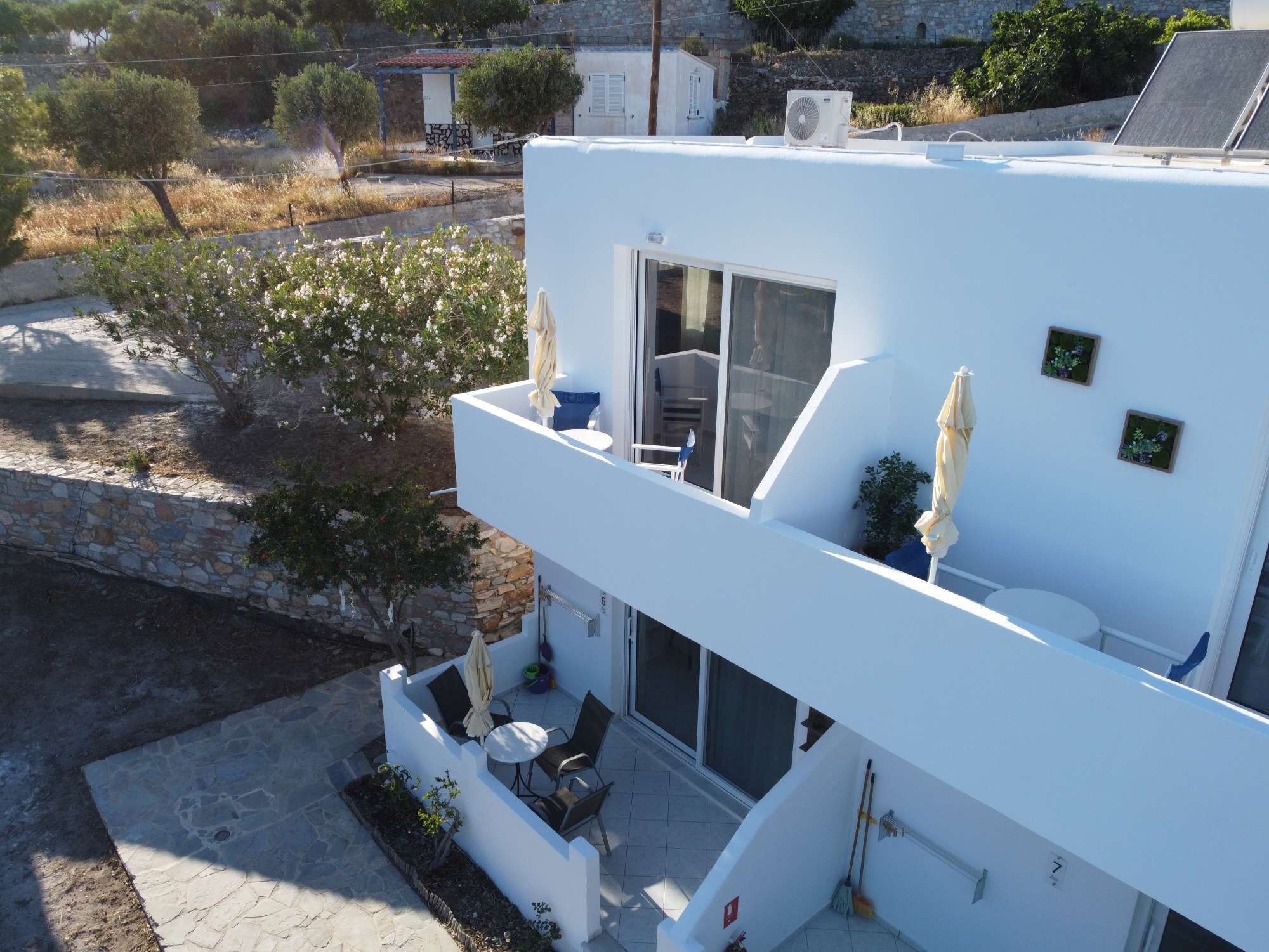 A modern white building with a balcony, a small table, and a chair.