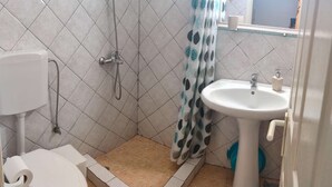 Un bany amb dutxa, vàter i rentapans.