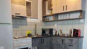 Uma cozinha com mesa de jantar, uma taça de vinho e diversos eletrodomésticos.
