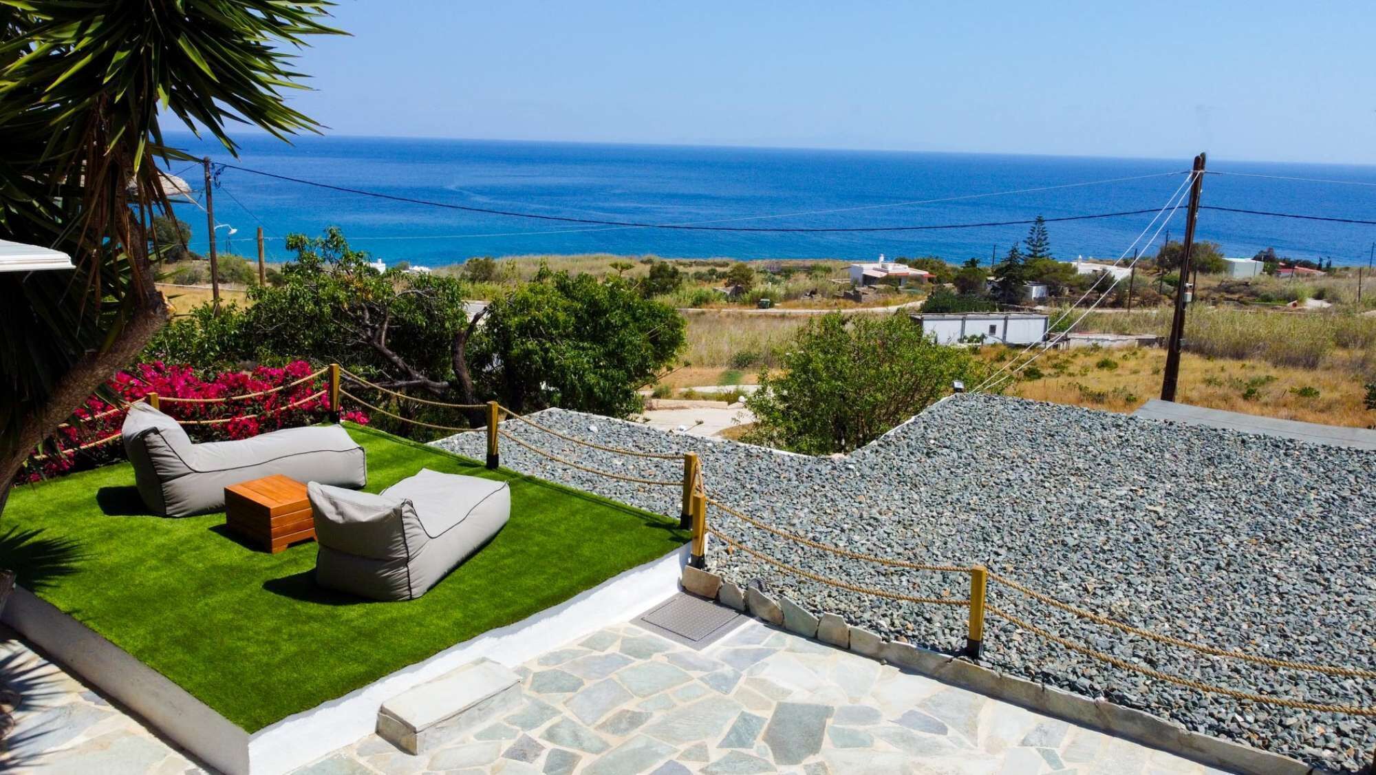 A patio with outdoor furniture overlooking a coastal landscape.
