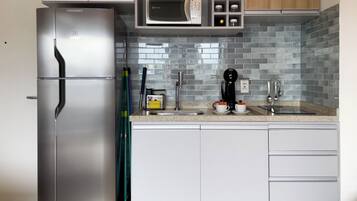 A modern kitchen with a stainless steel refrigerator, a microwave, and a coffee maker.