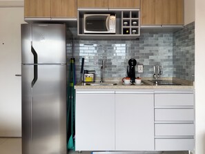 Une cuisine moderne équipée d’un réfrigérateur en acier inoxydable, d’un four à micro-ondes et d’une machine à café.