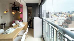 A modern dining area with a balcony overlooking a cityscape. - Genebra (São Paulo)