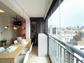 A modern dining area with a balcony overlooking a cityscape. - Genebra (São Paulo)