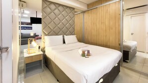 A modern hotel room with a large bed, a bedside table with a lamp, a wardrobe, and a mirror. - Genebra (São Paulo)