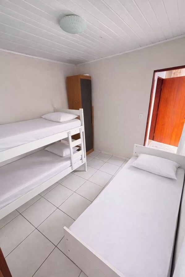 A room with bunk beds, a wardrobe, and a window.