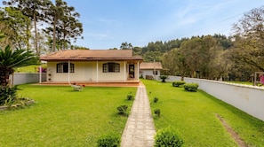 A house with a tiled roof, a paved pathway, and a well-maintained lawn.