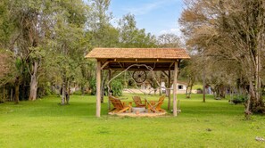Un kiosque doté d’un toit en tuiles, de bancs en bois et d’une grande structure en forme de roue.