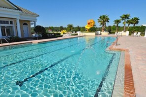 A swimming pool with clear blue water, surrounded by lounge chairs and palm trees. - Rosemont Retreat-5BR Private Pool Home Near Disney with Golf Resort Amenities (Davenport)