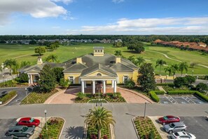 A large building with a central entrance, surrounded by a parking lot and greenery. - Rosemont Retreat-5BR Private Pool Home Near Disney with Golf Resort Amenities (Davenport)