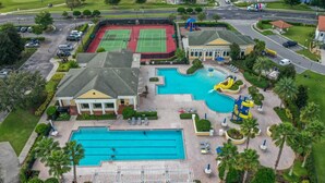 Ein Wohnhaus mit Schwimmbad, Tennisplätzen und einer überdachten Terrasse.