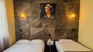 Een hotelkamer met twee bedden, een marmeren wand en een schilderij boven de bedden.