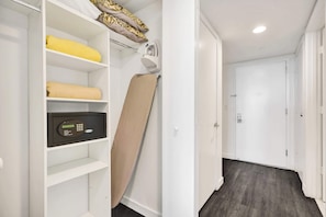 A hotel room with a white wardrobe, a digital control panel, and a beige ironing board. - Lovely Modern Studio - Canal View & Beach Access (Hallandale Beach)
