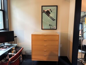 A room with a desk, chair, and a wooden cabinet.