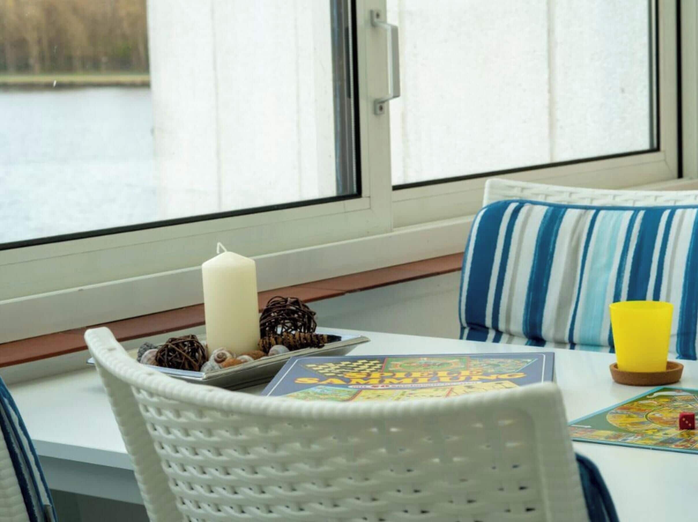 A cozy seating area with a table, a candle, and a board game.