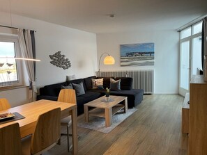 Ein stilvolles Wohnzimmer mit Sofa, Couchtisch und Essbereich.