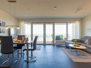 Ein modernes Wohnzimmer mit Essbereich, einer Couch und einem Couchtisch.