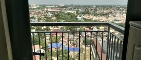 Un balcon donnant sur un quartier résidentiel, avec vue sur des maisons et des immeubles.