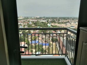 Un balcón con vista a una zona residencial, que incluye casas y edificios.