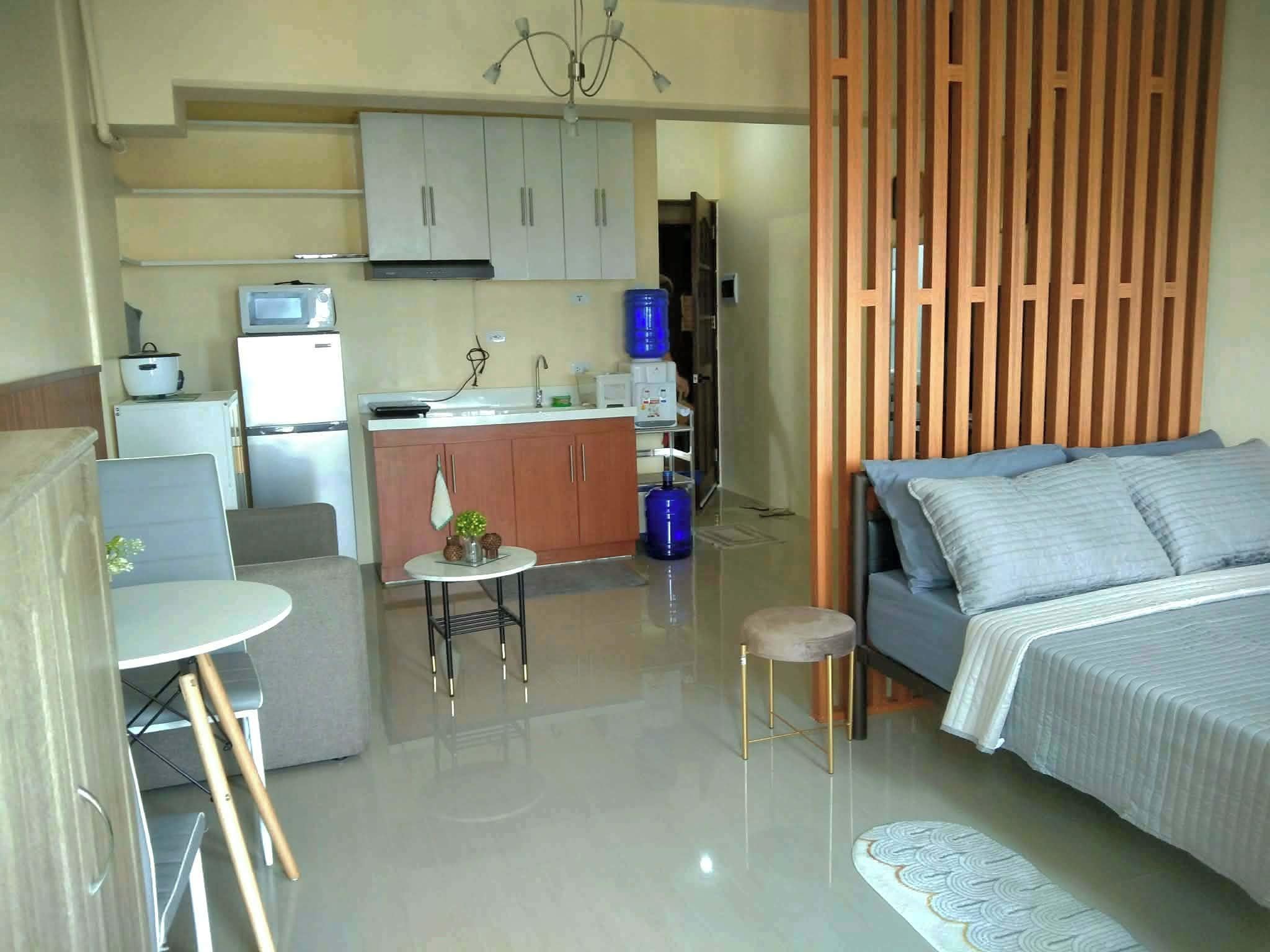 A compact living space with a kitchenette, a dining area, and a bed.