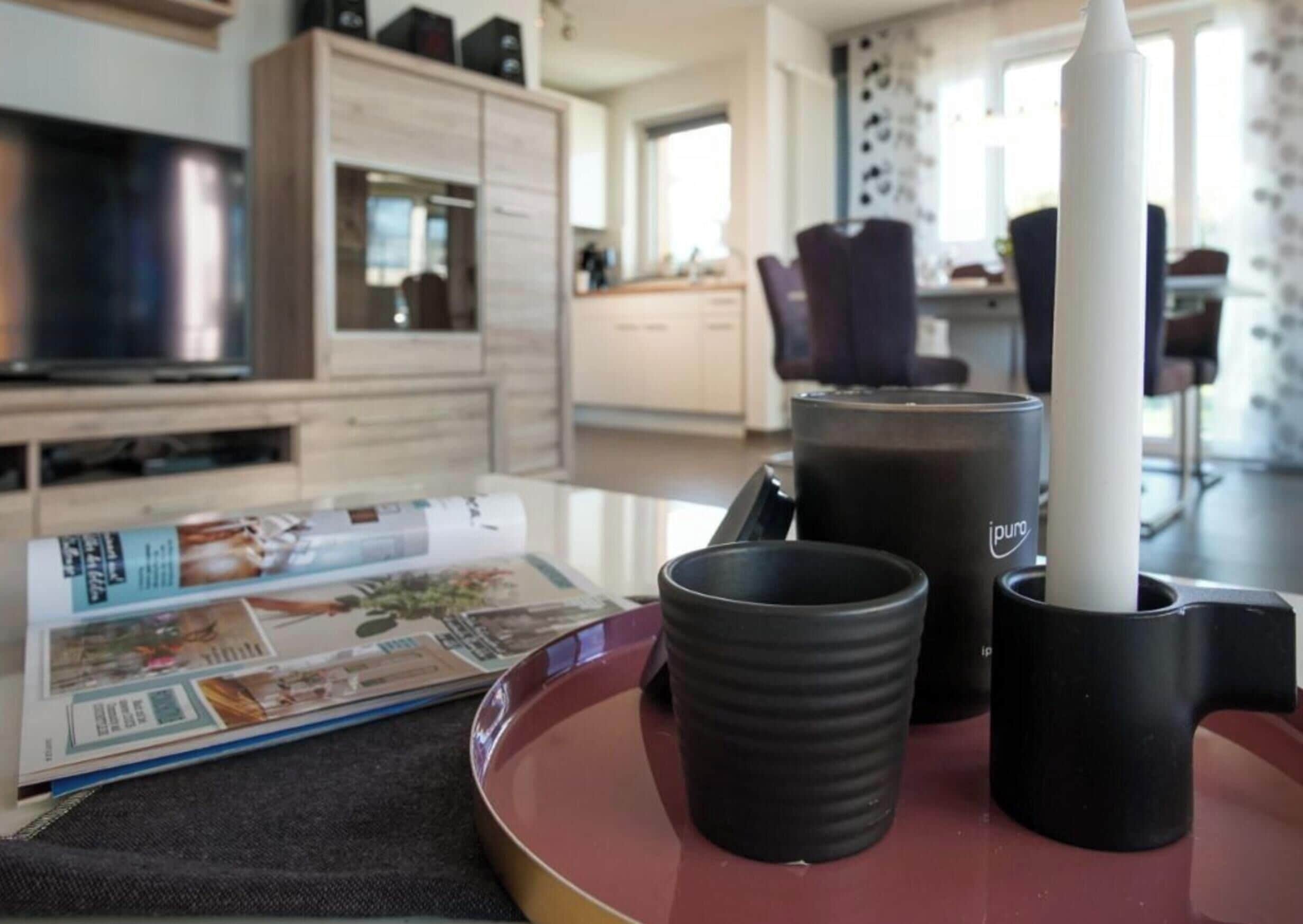 A living room with a magazine, a coffee machine, and a television.