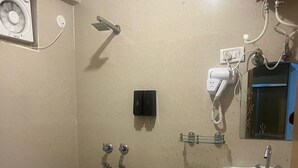 Ein Badezimmer mit Toilette, Bidet, Waschbecken und einem an der Wand befestigten Fön.